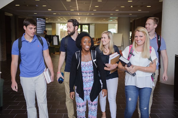 A group of law students walk through the law school lobby.