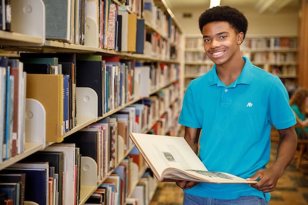 An early college student browses a library collection