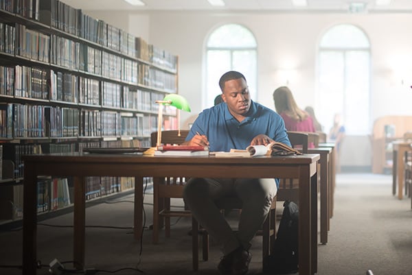 A student studies at a table in the Bruno Business Library