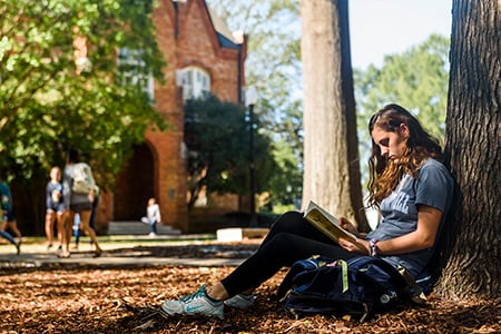 a student works on her laptop beneath denny chimes